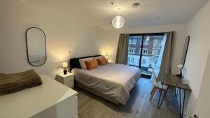 a bedroom with a bed and a desk and a window at Hemel Hives in Hemel Hempstead