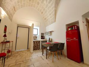 a kitchen with a red refrigerator and a table at Chez Liart 1 in Fasano