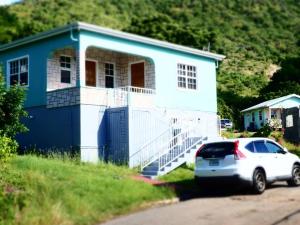 a blue house with a car parked in front of it at Fan-Ta-Sea in Johnsons Point