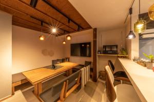 a kitchen and dining room with a wooden table and chairs at HIDA TAKAYAMA BASE - Traditional Japanese Garage House with Private Sauna in Takayama