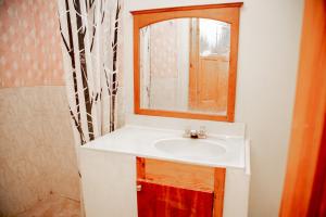 uma casa de banho com um lavatório e um espelho em MOONLIGHT HOTEL BAR RESTO em Hinche
