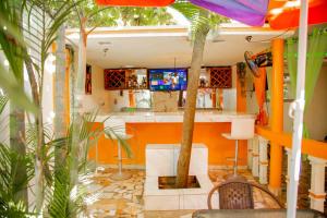een bar met een palmboom in het midden van een kamer bij MOONLIGHT HOTEL BAR RESTO in Hinche