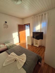 a bedroom with a bed and a flat screen tv at Hotel Nuar in Betim