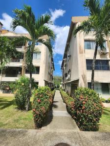 a walkway in front of a building with palm trees and flowers at Acogedor Apartamento Completo 2 Recamaras 2 Baños. in Panama City