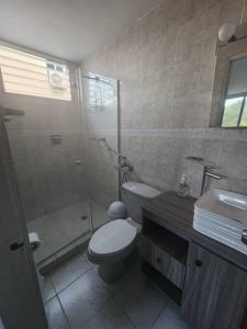 La salle de bains est pourvue de toilettes, d'une douche et d'un lavabo. dans l'établissement Acogedor Apartamento Completo 2 Recamaras 2 Baños., à Panama City