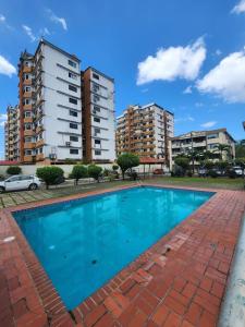 a large blue swimming pool in front of some buildings at Acogedor Apartamento Completo 2 Recamaras 2 Baños. in Panama City
