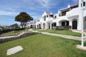 a large white house with a grass yard at APARTAMENTO SON BOU in Son Bou