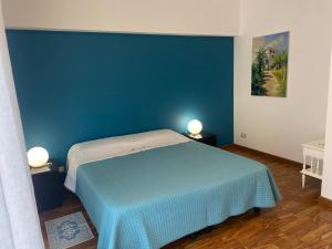 sypialnia z niebieską ścianą i łóżkiem w obiekcie Mareluce w mieście Letojanni