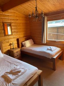 1 dormitorio con 2 camas en una cabaña de madera en The Fairways, Kenwick Retreats en Louth