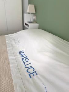 białe łóżko z napisem "hotel" w obiekcie Mareluce w mieście Letojanni