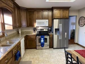 a kitchen with wooden cabinets and a stainless steel refrigerator at 4 Bedrooms~2 Baths Cute & Cozy, Excellent Location in Dubuque