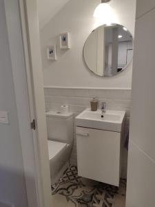 uma casa de banho branca com um lavatório e um espelho em Villa Memé Playa em Málaga