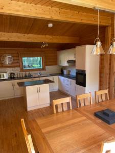 a kitchen with a table and a dining room at The Fairways, Kenwick Retreats in Louth