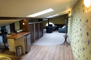 a living room with a desk and a room with a couch at Apartament na poddaszu in Zduńska Wola