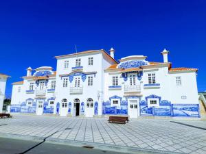 ein großes weißes Gebäude mit blauen Fliesen darauf in der Unterkunft Sal, Terra e Mar in Aveiro