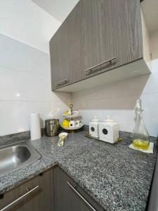 a kitchen counter with a sink and a microwave at Hermoso apartamento con piscina. in La Estrella