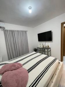 a bedroom with a large bed and a flat screen tv at Hermoso apartamento con piscina. in La Estrella