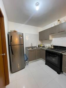 a kitchen with a stainless steel refrigerator and a stove at Hermoso apartamento con piscina. in La Estrella