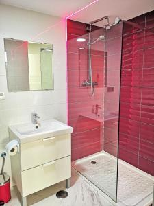 y baño de color rosa con lavabo y ducha. en OFIC/ESTUDIO CONIL S.A., en Conil de la Frontera