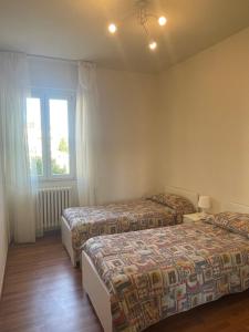 - une chambre avec 2 lits et une fenêtre dans l'établissement Appartamento - Porto San Giorgio, à Porto San Giorgio