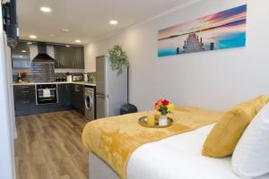 a bedroom with a white bed and a kitchen at Dane Duplex Studio Two – Cosy Coventry Haven in Coventry