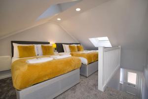a bedroom with two beds with yellow pillows at Dane Duplex Studio Two – Cosy Coventry Haven in Coventry