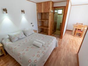 een kleine slaapkamer met een bed en een houten vloer bij Hotel Catripulli in Pucón