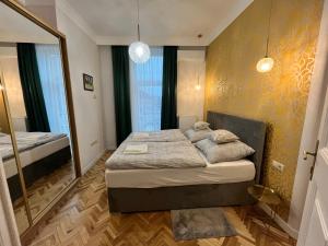ein Schlafzimmer mit einem Bett und einem großen Spiegel in der Unterkunft Ady1 Apartment in Kaposvár