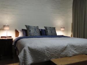a bedroom with a large bed with two lamps at Belle View Guest Suite in Hermanus