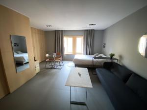 een kamer met een bank, een bed en een tafel bij Le Chat Qui Dort - Suites in Lille