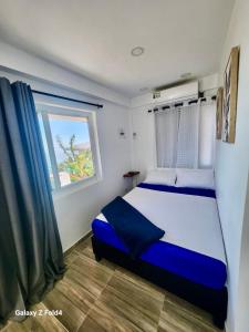 1 dormitorio con cama y ventana en Sea Breeze inn 102, en Providencia