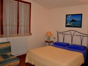 a bedroom with a bed and a window at Appartamenti Pian d'Alma in Punta Ala