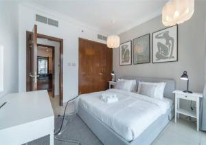 a white bedroom with a large bed and a table at BEST OFFER! One Bedroom with Downtown Views in Dubai