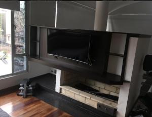 TV de pantalla plana en la sala de estar con chimenea en Casa de Huéspedes Santa María Hotel, en Bogotá