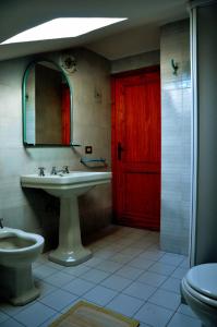 a bathroom with a red door and a sink and a toilet at Appartamenti Pian d'Alma in Punta Ala