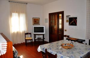 a living room with a table and a television at Appartamenti Pian d'Alma in Punta Ala