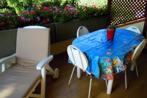 a table and chairs with a table and flowers at Appartamenti Pian d'Alma in Punta Ala