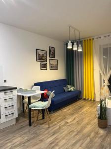 - un salon avec un canapé bleu et une table dans l'établissement Apartament Chiara, à Oleśnica