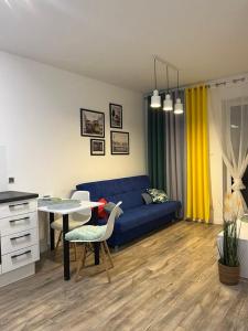 a living room with a blue couch and a table at Apartament Chiara z balkonem in Oleśnica