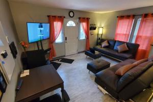 un soggiorno con un divano e una TV di Cozy Cottages across from the Food Trucks of Aloha mall ad Aloha