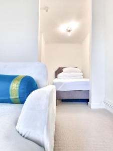 ein Zimmer mit 2 Betten und einem Stuhl darin in der Unterkunft Fresh and Sparkling - Free Parking in Crystal Palace