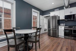 a kitchen with a table and chairs and a refrigerator at Flats on Front - Riverfront Gem Fast Wi-Fi 3F in Harrisburg