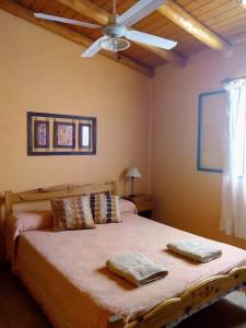 a bedroom with a large bed with two towels on it at INTI MAYU Cabañas in Mina Clavero +10 photos