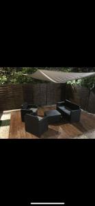 dos sofás sentados bajo una sombrilla en un patio en Studio ensoleillé sur Montpellier en Montpellier