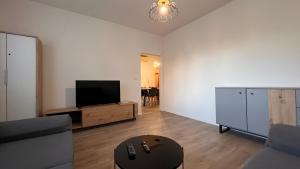 a living room with a flat screen tv and a couch at Air conditioned 3 room apartment, near Technopol in Bratislava