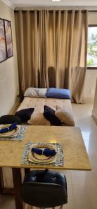 Habitación con 2 camas y mesa de madera. en Apartamento Perfeito águas claras en Águas Claras