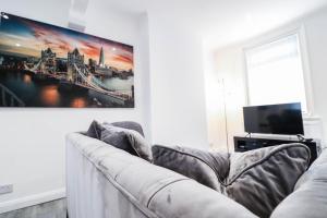 a living room with a couch and a tv at Great 3 Bed Refurbished House in Colchester