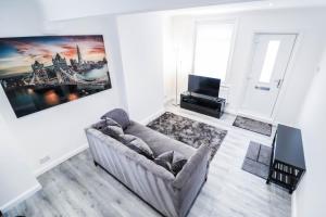 a living room with a couch and a tv at Great 3 Bed Refurbished House in Colchester