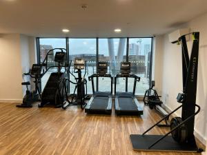 a gym with treadmills and exercise equipment in a room at Manchester's Luxurious 3-Bed Haven with Balcony & Free Parking - Canal Views & Proximity to Manchester United in Manchester