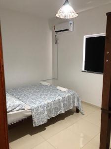 a small room with a bed and a light at Beira Mar Residencial in Guaibim